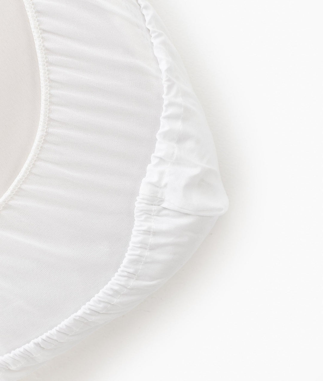 Macro view of white 100% cotton fitted sheet elasticized hem and knit texture