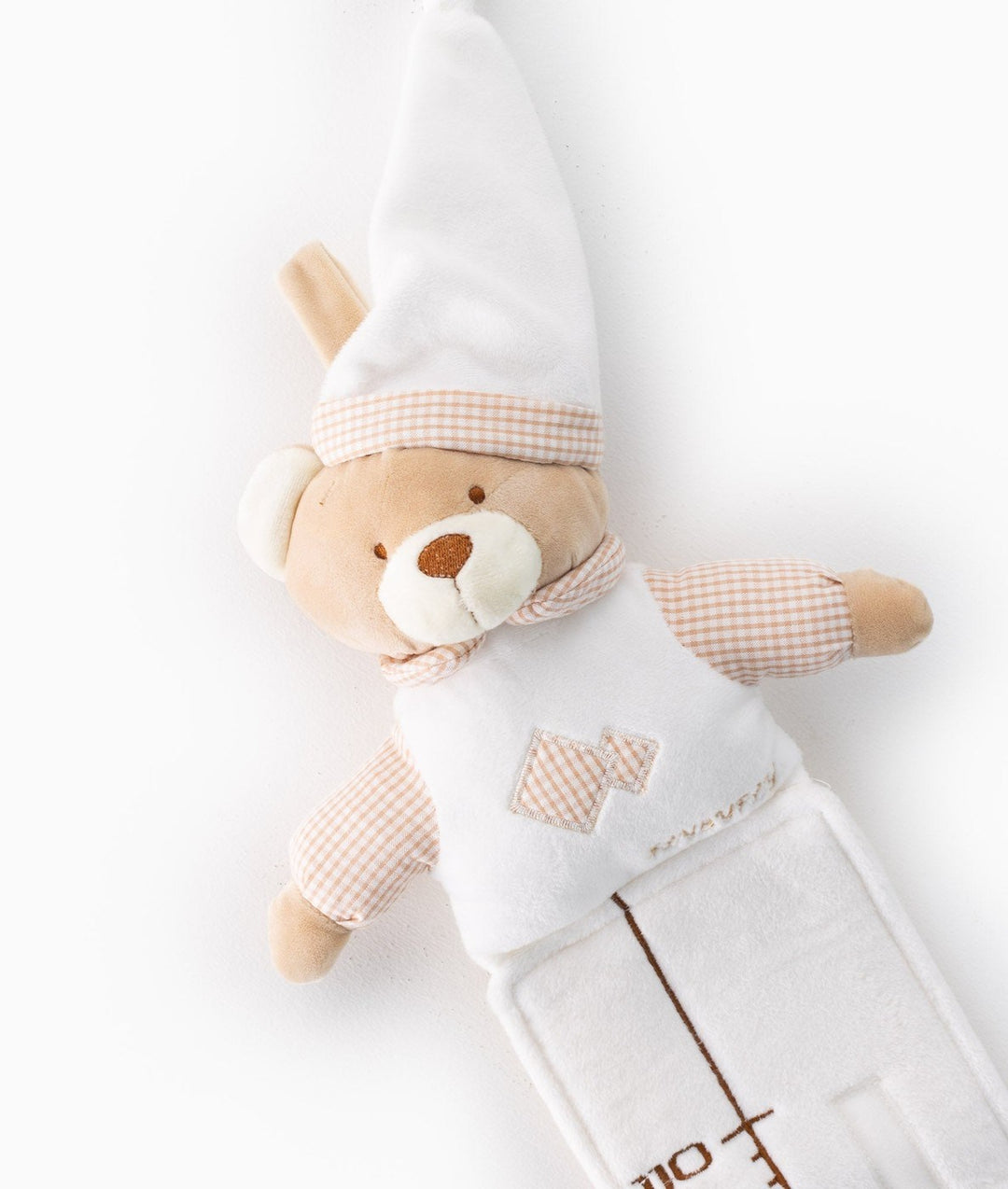 Beige teddy bear head on white baby growth chart featuring tall pointed hat with peach gingham trim