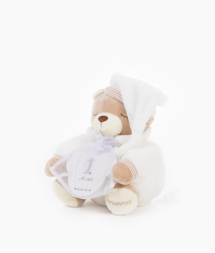 Beige teddy bear holding white 1 Month milestone card with embroidered logo detail