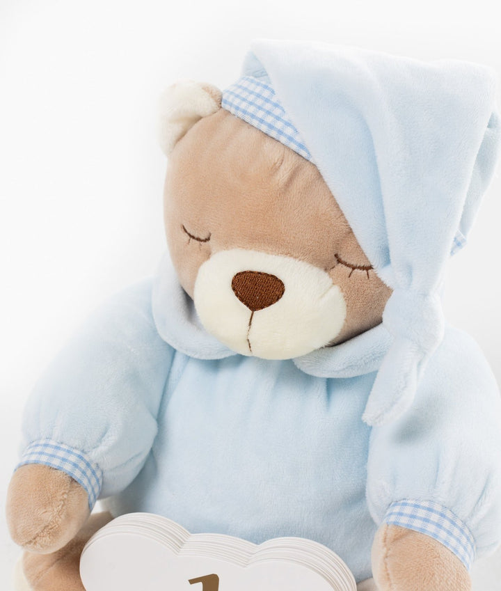 Blue hooded teddy bear holding stack of white cloud-shaped milestone cards