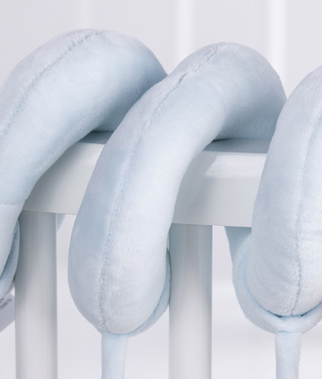 Macro view of light blue plush spiral tube texture and soft stitching on cot rail