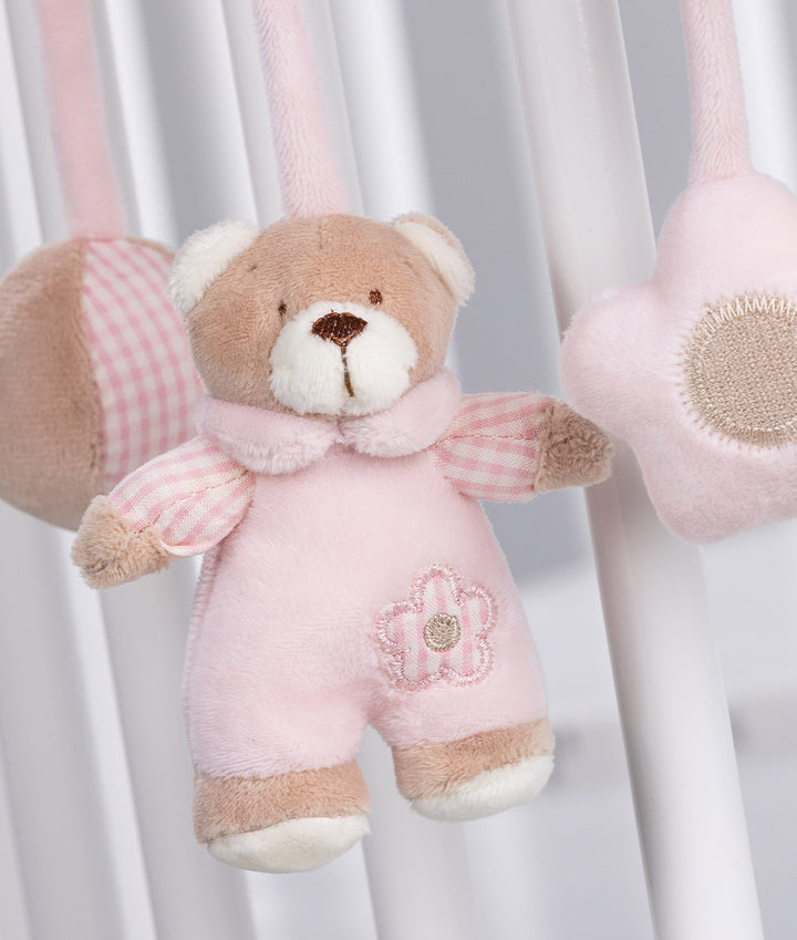 Close up of pink gingham sleeve teddy bear charm and textured star rattle on spiral activity toy