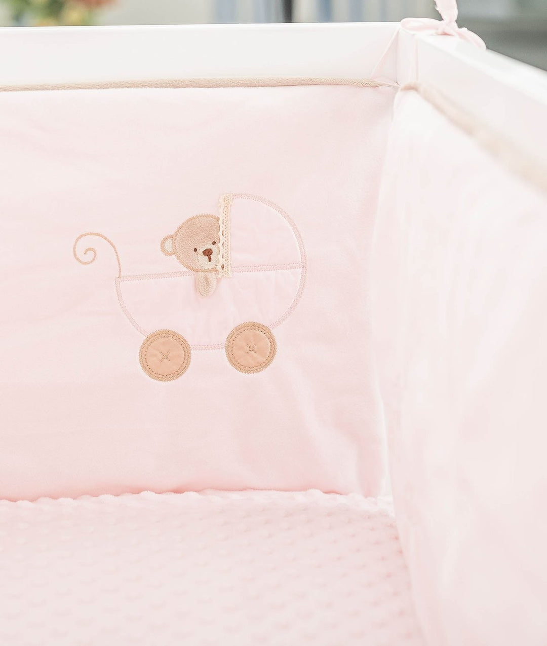 Double-sided cot bumper detail with embroidered teddy bear in pram design