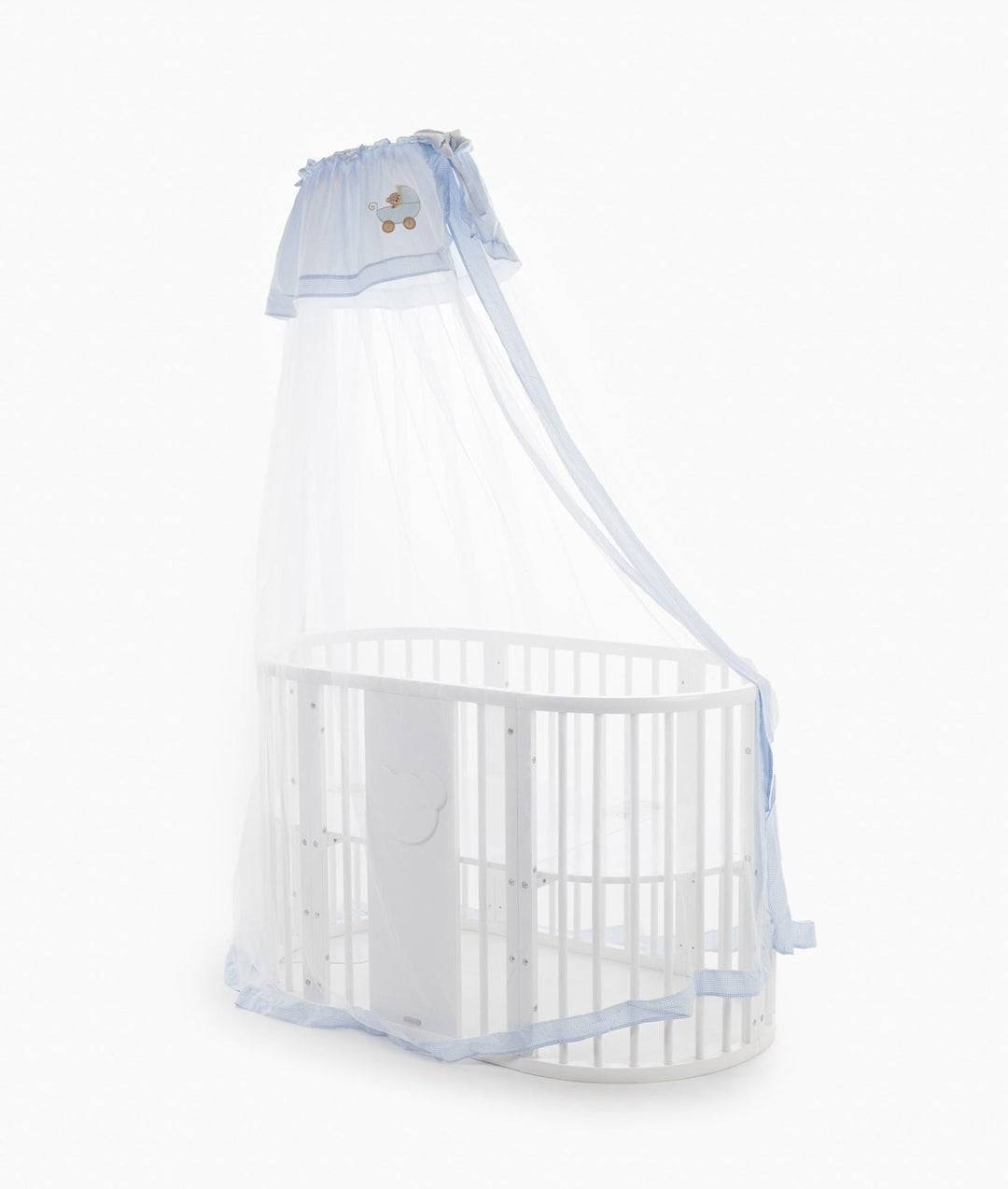 Sheer white netting cot canopy draped over white oval crib with light blue gingham hem trim and side tie straps