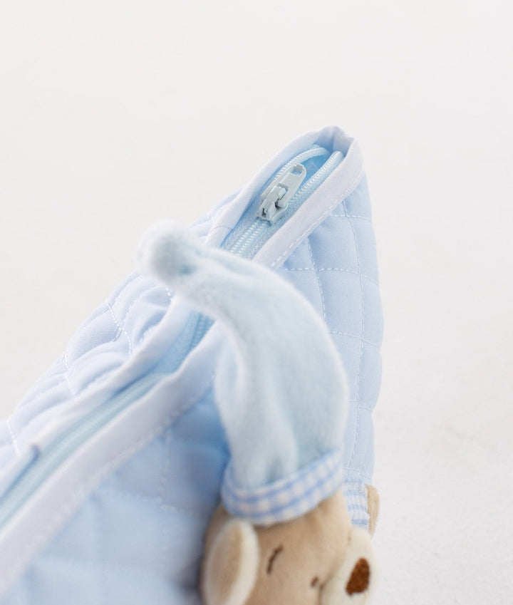Close-up of silver zipper pull, white piping, and soft plush bear hat texture on blue bag