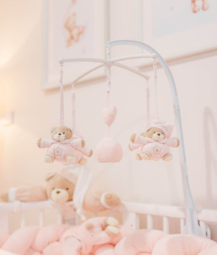 White arched baby mobile stand with pink checkered bear plushies and heart ornaments
