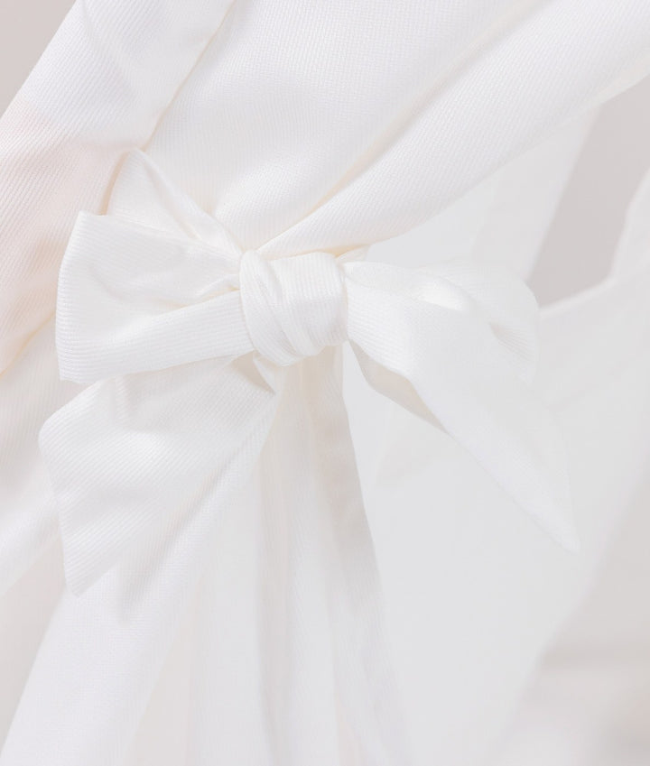 Detail of white cotton tie-back knot at the entrance of a grey and white teepee